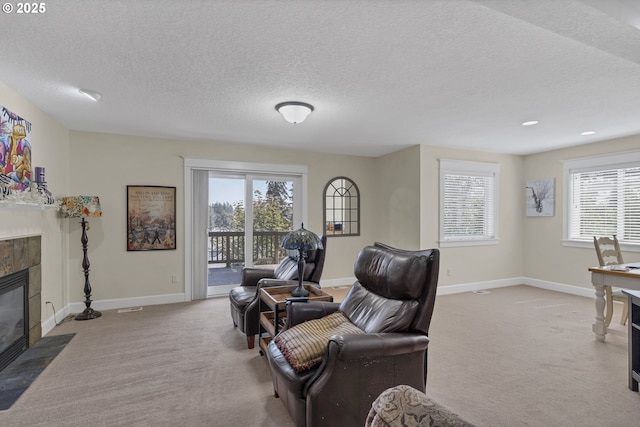 living room featuring a fireplace, light colored carpet, and a textured ceiling