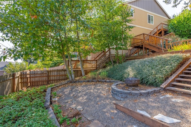 view of yard with a deck and an outdoor fire pit