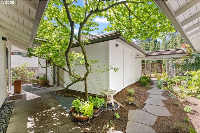 view of side of home featuring fence and a patio area