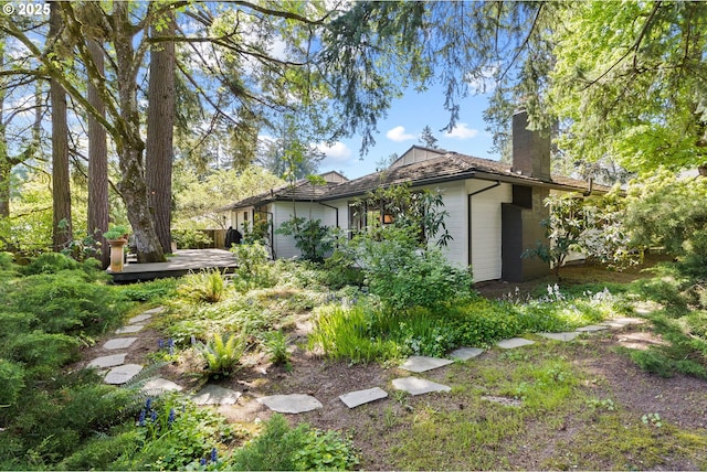 view of side of property with a wooden deck and a chimney
