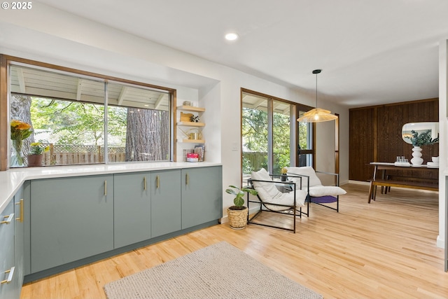 interior space with pendant lighting, open shelves, light wood-type flooring, light countertops, and recessed lighting