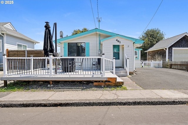 view of front of home featuring an outdoor structure, fence, and a wooden deck