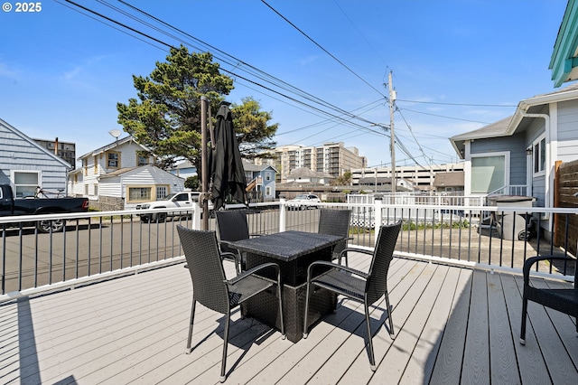 wooden terrace featuring a residential view and outdoor dining space