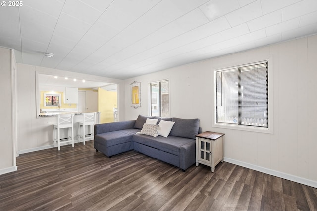 living room featuring baseboards and dark wood finished floors