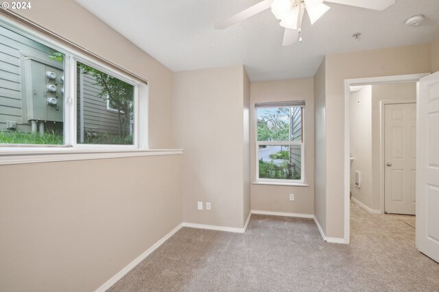 unfurnished bedroom featuring light carpet, baseboards, and ceiling fan