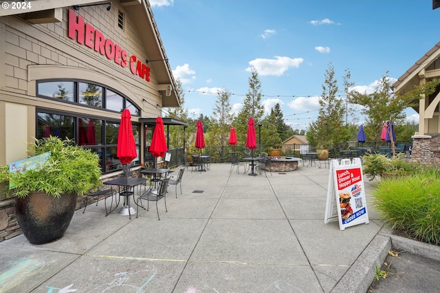 view of property's community featuring an outdoor fire pit, fence, and a patio