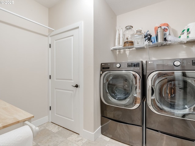 laundry area with washer and clothes dryer, baseboards, and laundry area