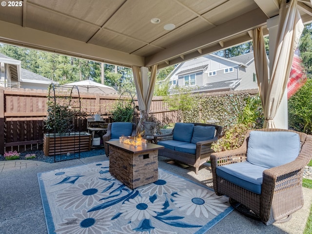 view of patio with fence and an outdoor living space with a fire pit