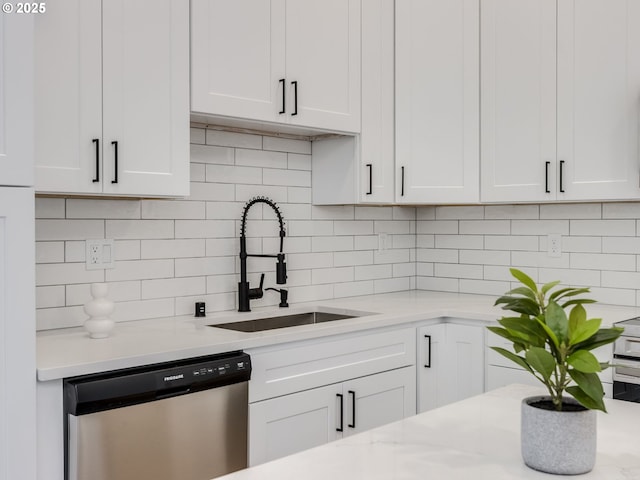 kitchen featuring a sink, dishwasher, white cabinets, and tasteful backsplash