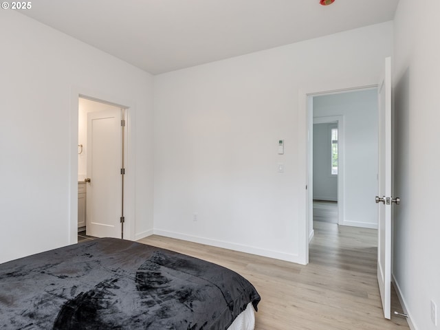 bedroom featuring baseboards and light wood-style flooring