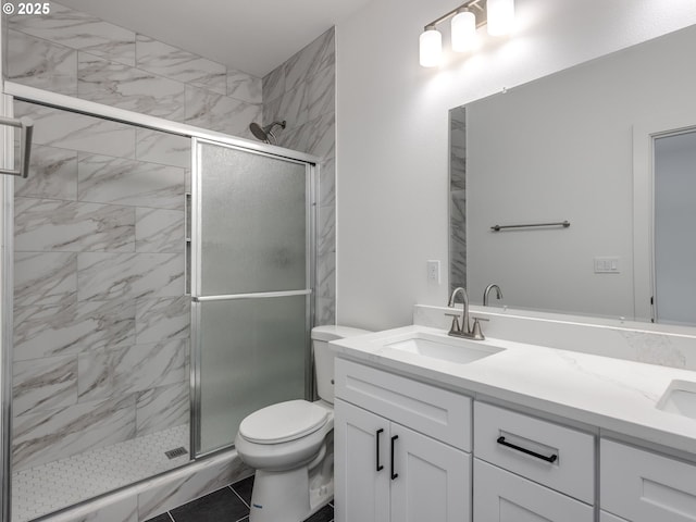 full bath featuring double vanity, toilet, a shower stall, and a sink