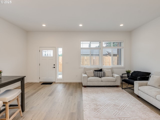 living area with light wood-type flooring, recessed lighting, and baseboards