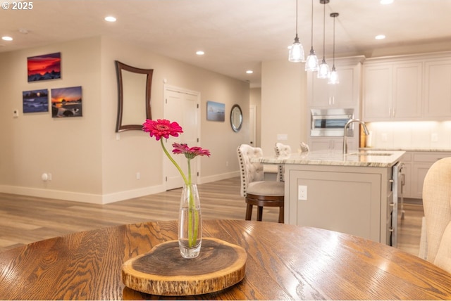 dining area featuring light wood finished floors, baseboards, and recessed lighting