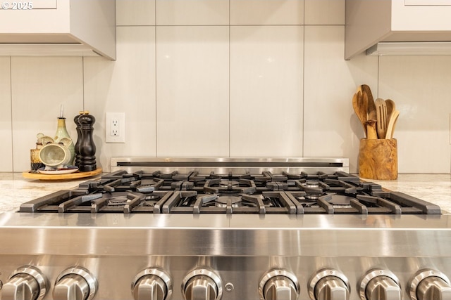 details with gas range oven and light stone countertops