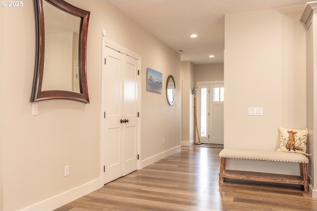 hall with baseboards, wood finished floors, and recessed lighting