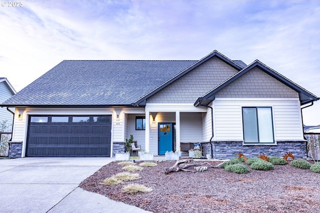 view of front facade with a garage, stone siding, roof with shingles, and concrete driveway