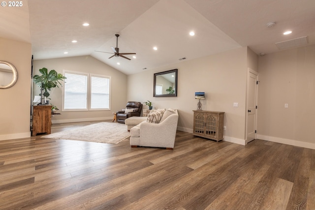 living area with a ceiling fan, lofted ceiling, baseboards, and wood finished floors