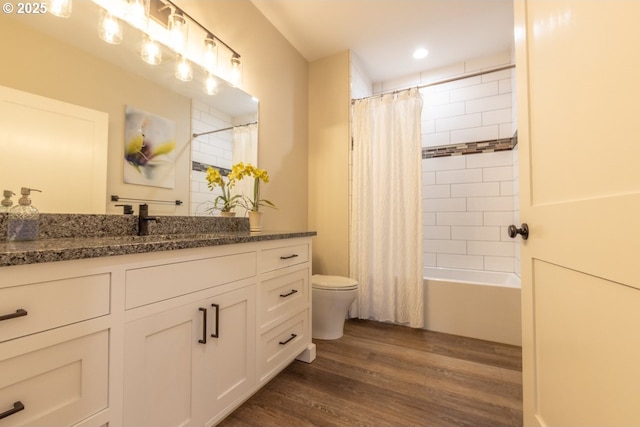 bathroom with vanity, shower / bath combination with curtain, wood finished floors, and toilet