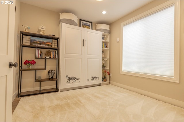 interior space featuring carpet, baseboards, and a wealth of natural light