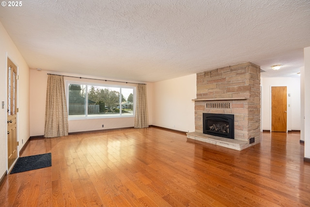 unfurnished living room with hardwood / wood-style flooring, a fireplace, and a textured ceiling