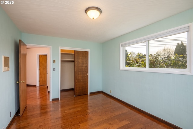 unfurnished bedroom featuring hardwood / wood-style floors and a closet