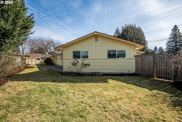 view of side of property featuring a storage shed and a lawn