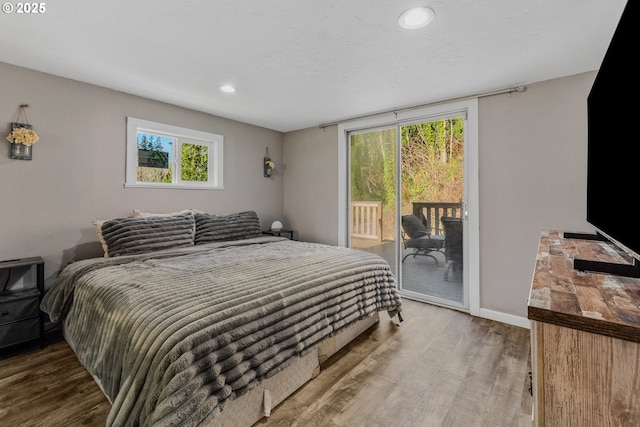 bedroom with hardwood / wood-style floors and access to outside