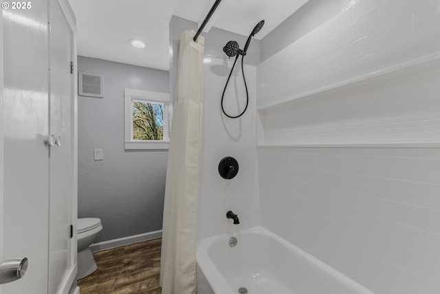 bathroom featuring hardwood / wood-style flooring, shower / bath combo, and toilet