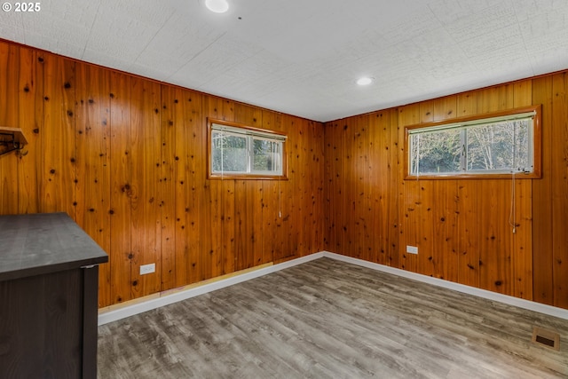 empty room featuring hardwood / wood-style flooring and wood walls