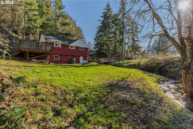 view of yard with central AC and a deck