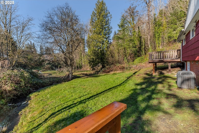 view of yard featuring cooling unit and a deck