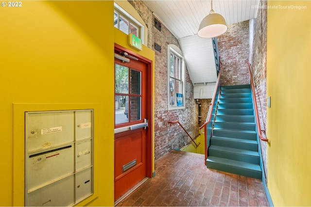 1325 NW Flanders St, Portland, OR 97209 - staircase with brick floor, brick wall, and wooden ceiling