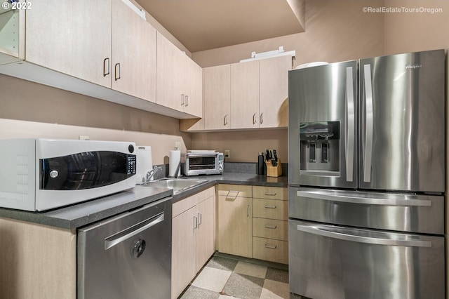 1325 NW Flanders St, Portland, OR 97209 - kitchen featuring light brown cabinetry, stainless steel appliances, a sink, and a toaster