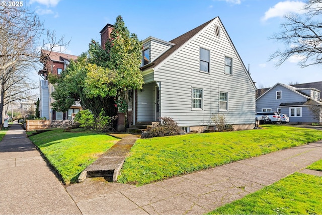 view of front facade with a front yard and a chimney