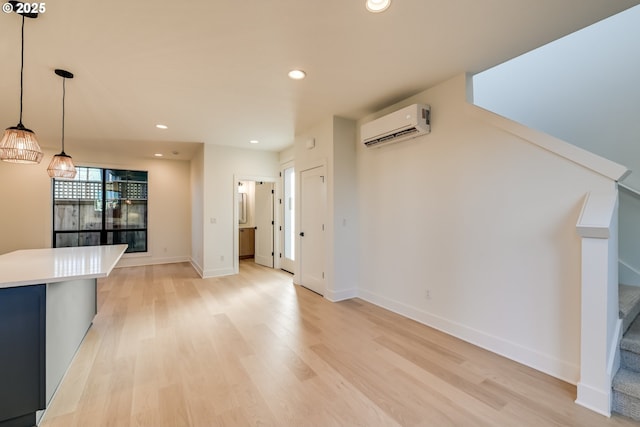 unfurnished living room with baseboards, stairway, a wall mounted air conditioner, light wood-style floors, and recessed lighting