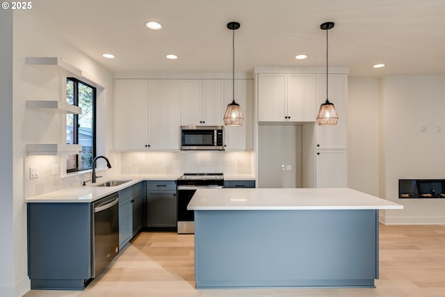 kitchen featuring white cabinetry, appliances with stainless steel finishes, light countertops, and a center island