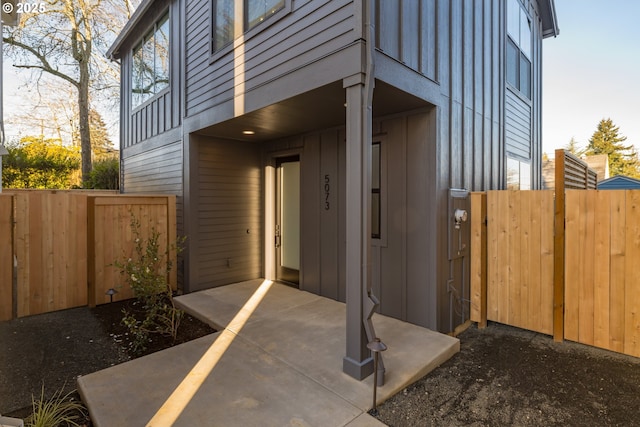 view of home's exterior with a patio, board and batten siding, and fence