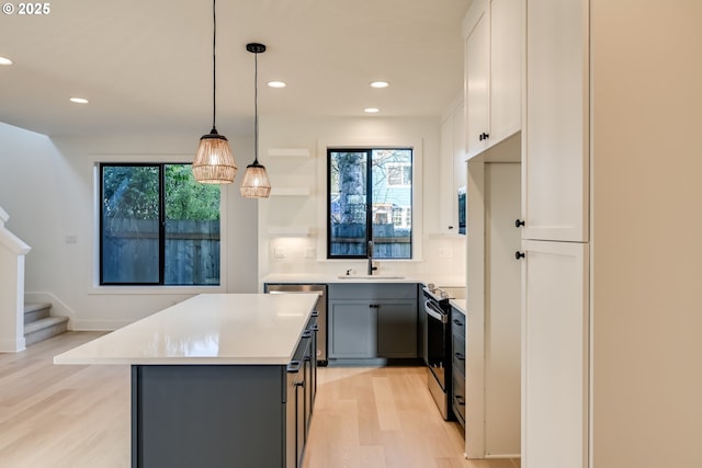 kitchen featuring electric range, light countertops, gray cabinetry, white cabinetry, and pendant lighting