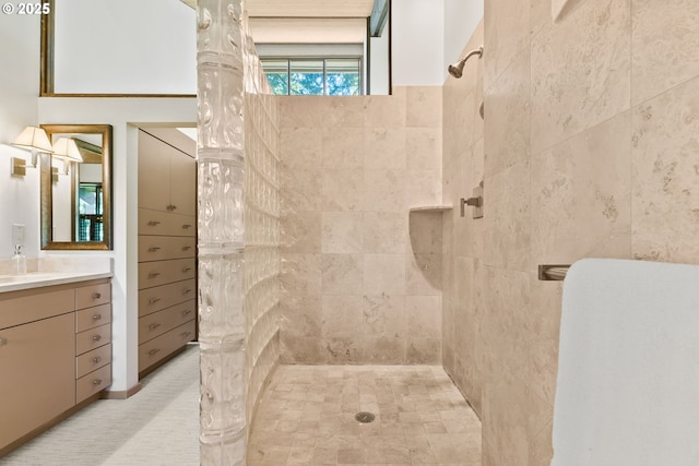 full bathroom with tiled shower and vanity