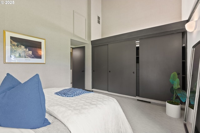 bedroom with a high ceiling and a closet