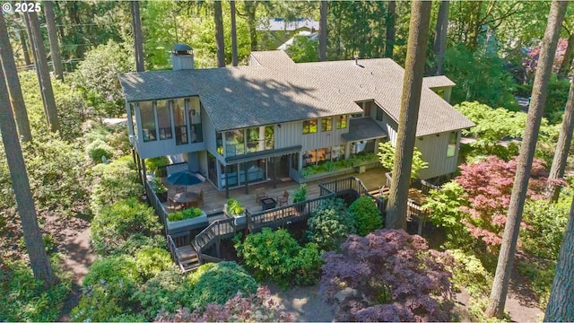 back of house featuring a shingled roof, a chimney, stairs, and a deck