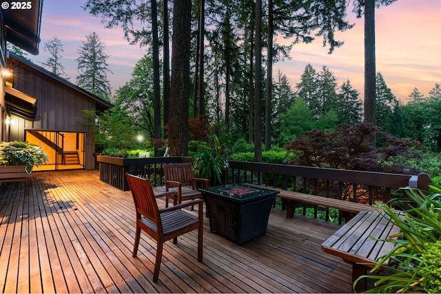 deck at dusk featuring an outdoor fire pit