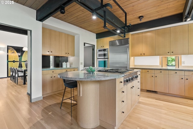 kitchen featuring light brown cabinetry, stainless steel appliances, light wood-style floors, wooden ceiling, and beamed ceiling