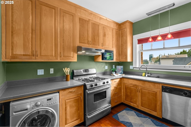 2083 NW Johnson St Unit 45, Portland, OR 97209 - kitchen with appliances with stainless steel finishes, washer / clothes dryer, a sink, range hood, and dark wood-style floors