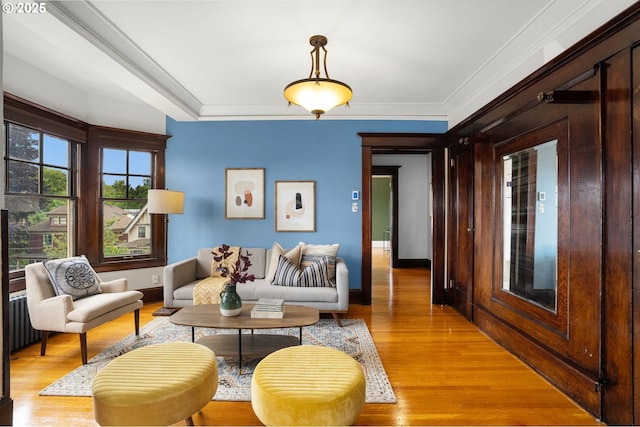 2083 NW Johnson St Unit 45, Portland, OR 97209 - living room featuring light wood-style floors, baseboards, ornamental molding, and radiator heating unit