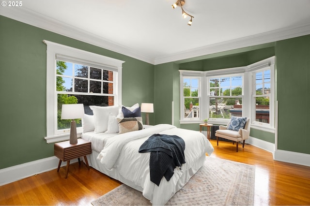2083 NW Johnson St Unit 45, Portland, OR 97209 - bedroom with baseboards, multiple windows, ornamental molding, wood finished floors, and radiator