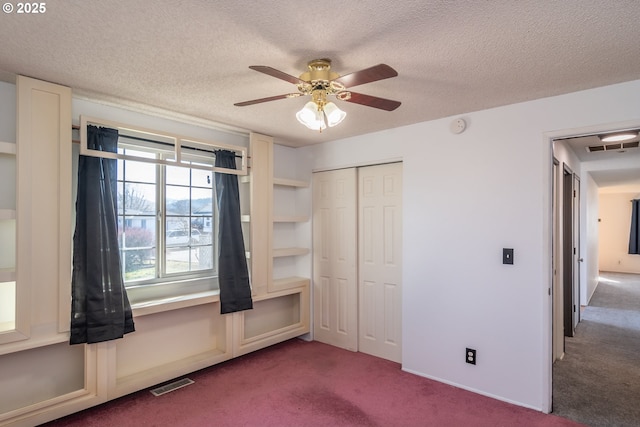 unfurnished bedroom with a closet, visible vents, carpet floors, and a textured ceiling