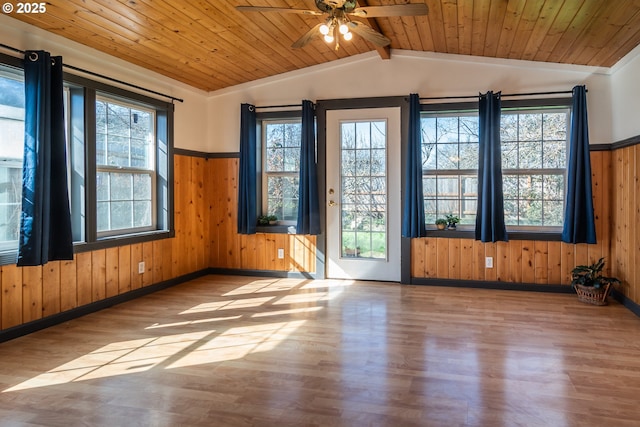 empty room with vaulted ceiling with beams, wood ceiling, a ceiling fan, and wood finished floors