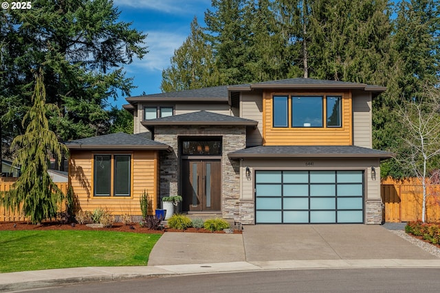 view of front of home with an attached garage, a shingled roof, fence, stone siding, and driveway