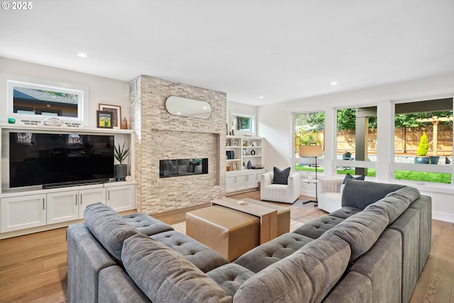 living area featuring light wood-style floors, a fireplace, and recessed lighting